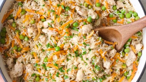 One-pot chicken rice with vegetables and herbs in a deep pan