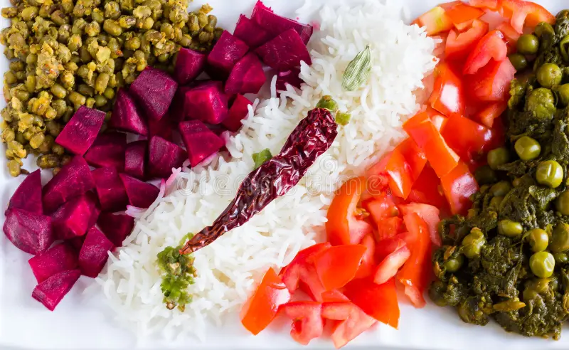 Colorful vegetarian platter with curry, lentils, rice, and salad